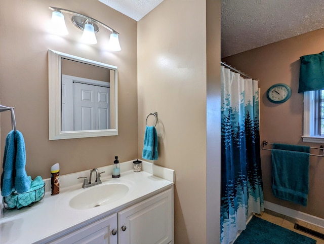 bathroom with tile patterned floors, curtained shower, vanity, and a textured ceiling