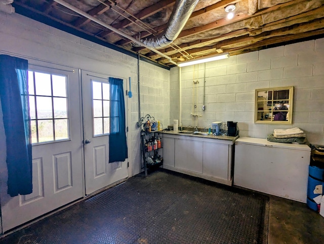 below grade area with concrete block wall and a sink