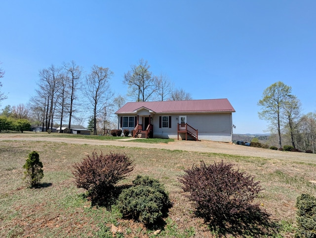 ranch-style house with a front lawn and metal roof