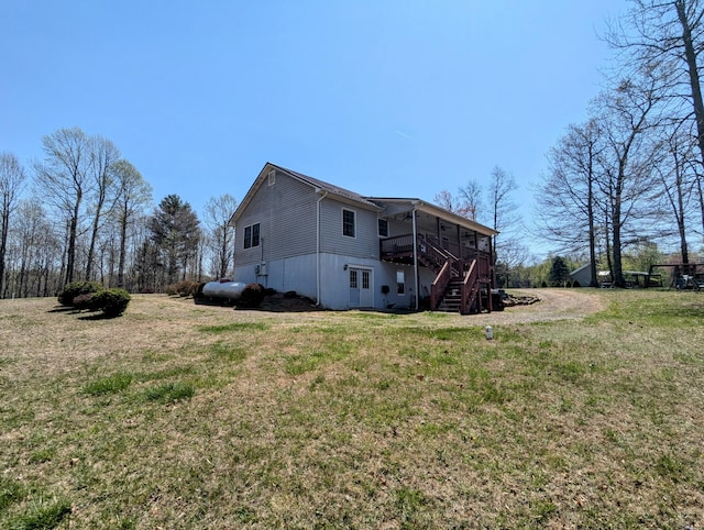 rear view of property with a yard, stairway, and a deck