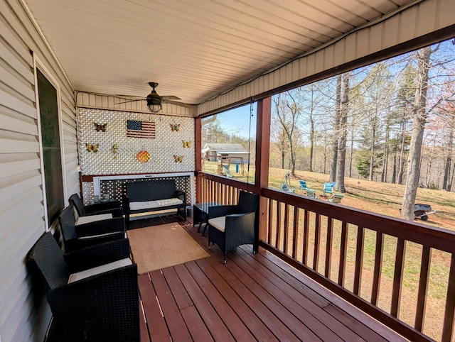 wooden deck featuring outdoor lounge area and ceiling fan
