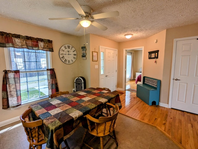 dining area with wood finished floors, a textured ceiling, baseboards, and ceiling fan