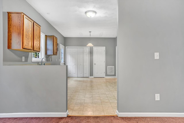 1920 Connors Ct, Salem, VA 24153 - kitchen featuring brown cabinetry, baseboards, pendant lighting, and light carpet
