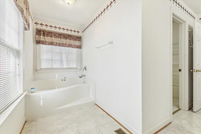 bathroom with a garden tub and visible vents