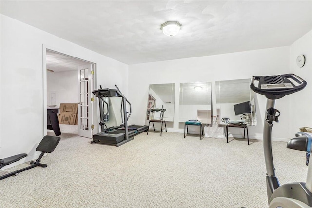 exercise room featuring baseboards and carpet