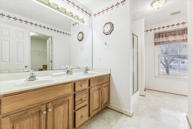 bathroom featuring double vanity, visible vents, a stall shower, and a sink