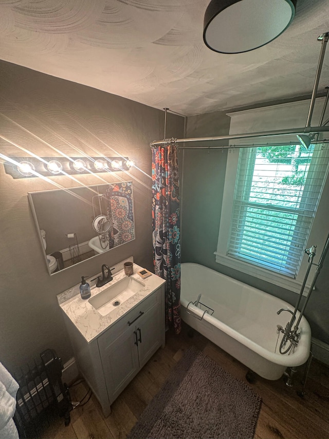 1705 Chapman Ave SW, Roanoke, VA 24016 - full bath featuring wood finished floors, a freestanding tub, vanity, and a shower with curtain