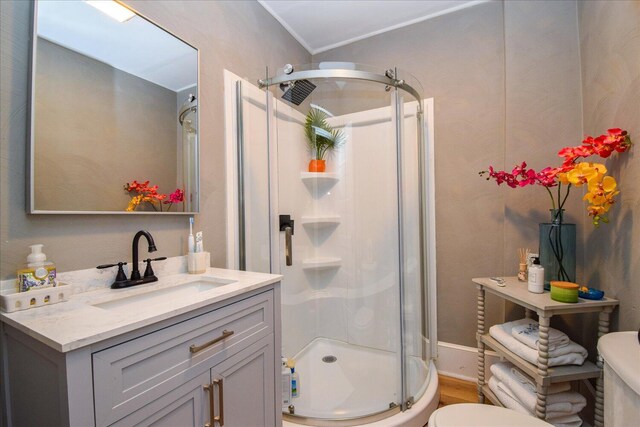 bathroom featuring a shower stall, toilet, crown molding, and vanity