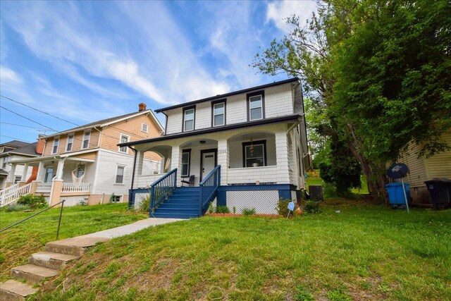 view of front of home featuring stairs, a porch, a front lawn, and central AC unit