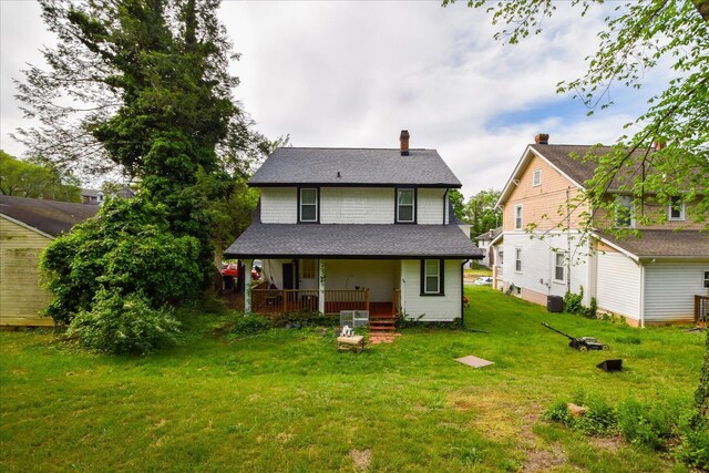 back of property featuring a yard, central air condition unit, a chimney, and covered porch