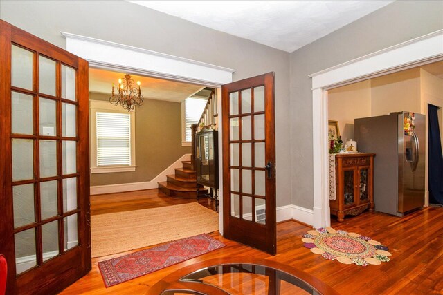 interior space with an inviting chandelier, wood finished floors, and french doors