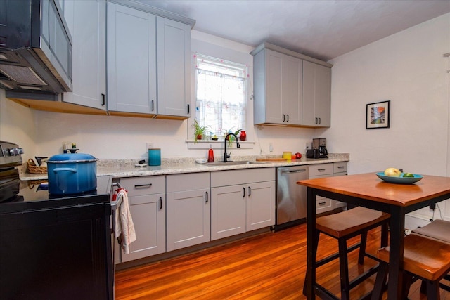 kitchen with dark wood-style floors, a sink, appliances with stainless steel finishes, and gray cabinets