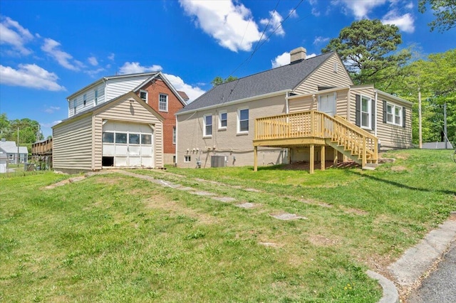 rear view of property with a yard, central air condition unit, a detached garage, and a deck