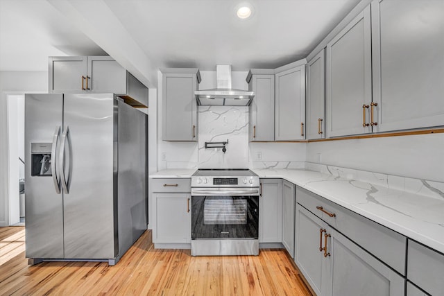 2288 Mud Pike Rd, Christiansburg, VA 24073 - kitchen with light wood finished floors, wall chimney exhaust hood, light stone counters, gray cabinetry, and appliances with stainless steel finishes