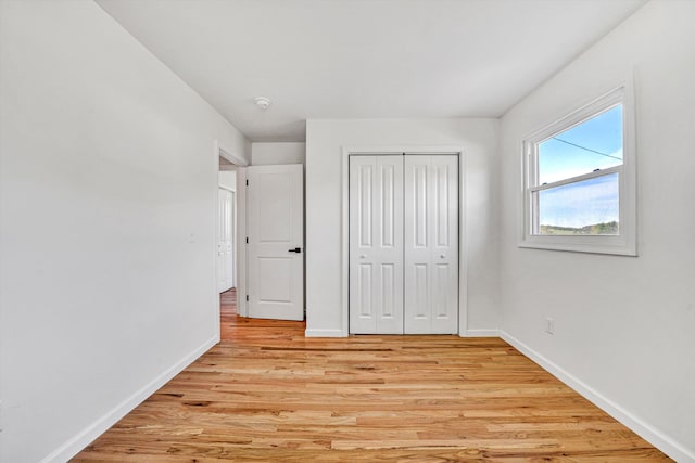 2288 Mud Pike Rd, Christiansburg, VA 24073 - unfurnished bedroom with baseboards, light wood-type flooring, and a closet