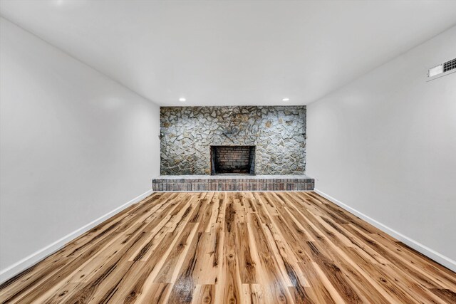 2288 Mud Pike Rd, Christiansburg, VA 24073 - unfurnished living room with wood finished floors, visible vents, a stone fireplace, and baseboards