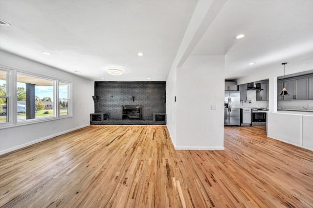 2288 Mud Pike Rd, Christiansburg, VA 24073 - unfurnished living room with a fireplace, recessed lighting, light wood-style floors, and baseboards