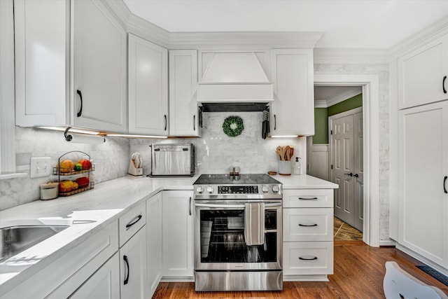 kitchen with white cabinets, custom exhaust hood, electric range, and wood finished floors
