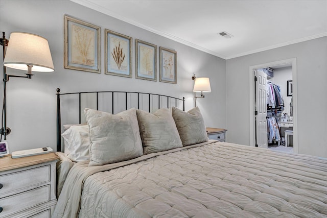 bedroom with a spacious closet, ornamental molding, and visible vents