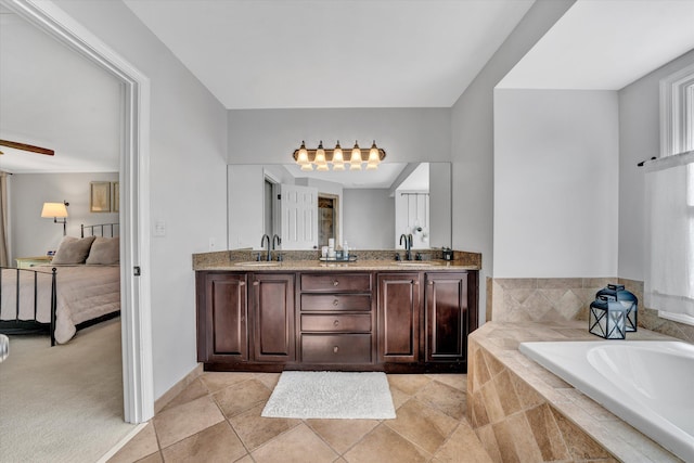 ensuite bathroom with connected bathroom, double vanity, a sink, and a bath