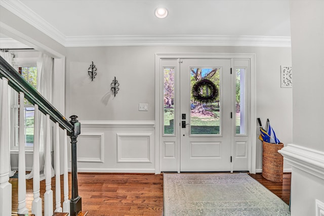 foyer featuring stairway, crown molding, and wood finished floors