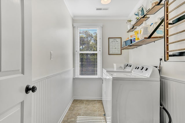 washroom with wainscoting, ornamental molding, laundry area, and washing machine and dryer