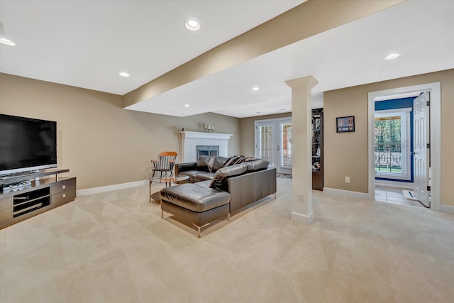 living room with baseboards, a wealth of natural light, a fireplace, and light colored carpet