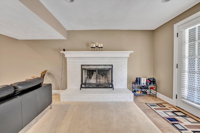tiled living area with baseboards and a fireplace