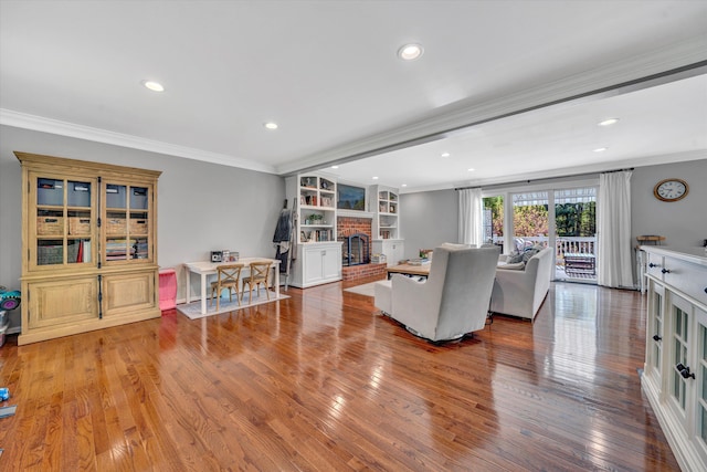 living room with ornamental molding, a fireplace, recessed lighting, and wood finished floors