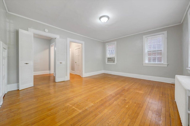 unfurnished bedroom with crown molding, light wood-style flooring, and baseboards