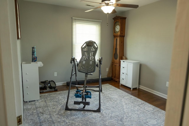 workout room with baseboards, visible vents, a ceiling fan, and dark wood-type flooring