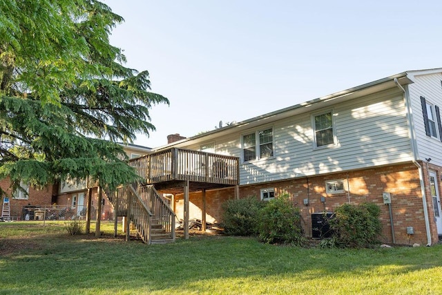 rear view of property with brick siding, a wooden deck, a yard, and stairway