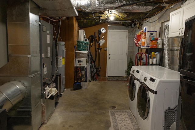 unfinished basement with heating unit, water heater, and washer and dryer