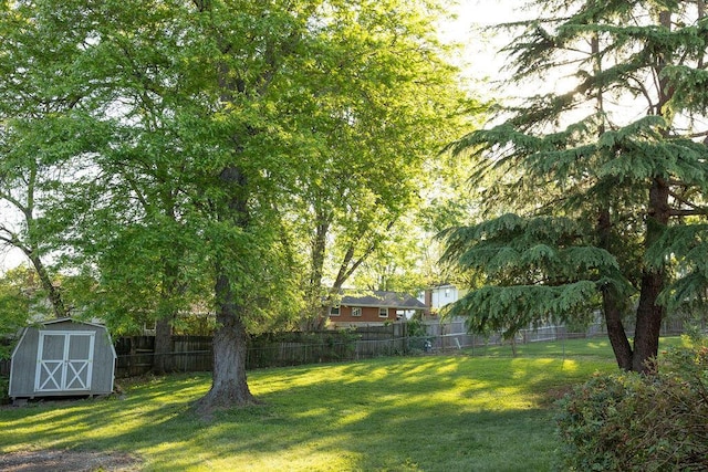 view of yard with a fenced backyard, an outbuilding, and a storage shed
