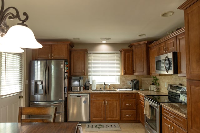kitchen featuring a sink, brown cabinetry, and stainless steel appliances