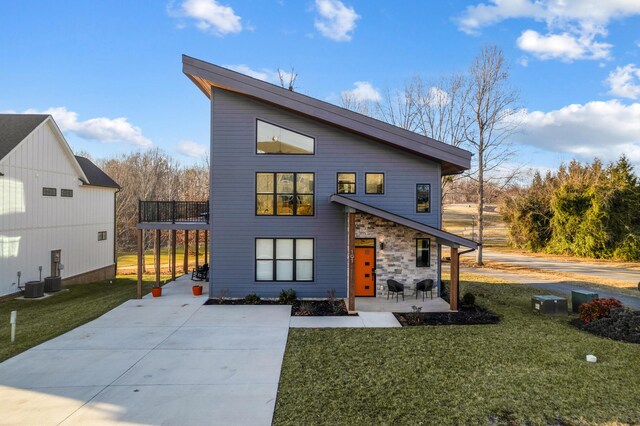101 Retreat Ln, Huddleston, VA 24104 - view of front of home with a balcony, concrete driveway, a front lawn, stone siding, and a patio