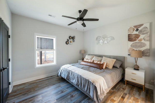 bedroom featuring baseboards, wood finished floors, visible vents, and ceiling fan