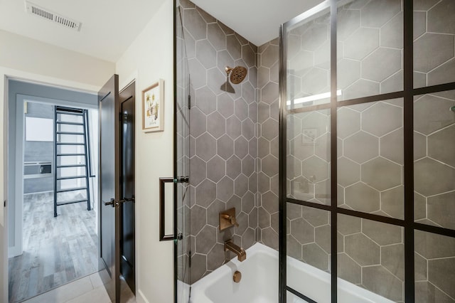 full bath with baseboards, shower / washtub combination, wood finished floors, and visible vents