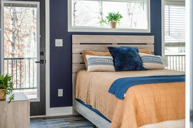 bedroom with wood finished floors and multiple windows