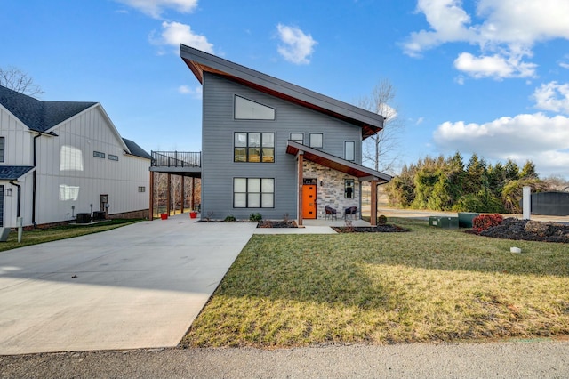 contemporary house featuring central air condition unit, stone siding, a front lawn, and concrete driveway