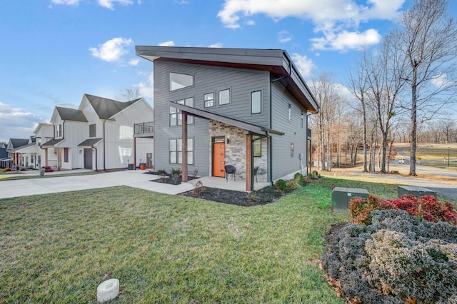 rear view of property with stone siding and a lawn