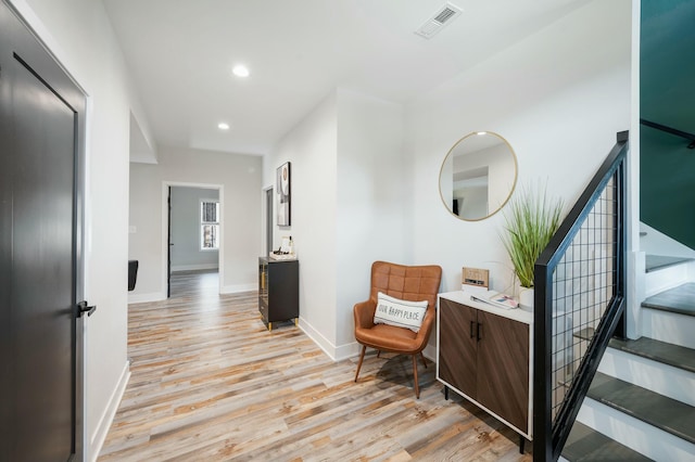 hall featuring light wood-type flooring, baseboards, recessed lighting, and visible vents