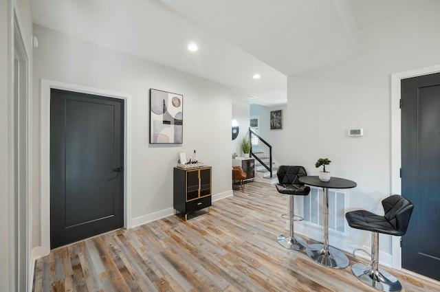 entrance foyer with baseboards, wood finished floors, stairs, and recessed lighting