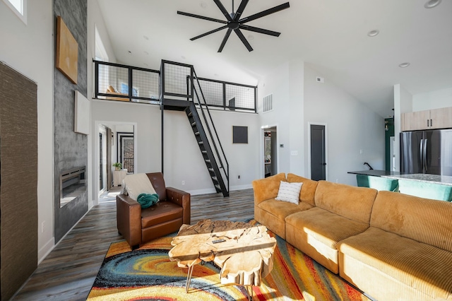 living room with high vaulted ceiling, a ceiling fan, wood finished floors, and visible vents