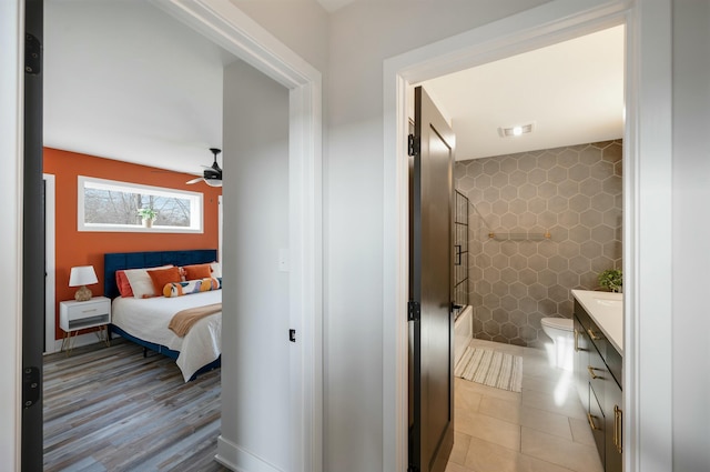 interior space with tile walls, visible vents, and connected bathroom