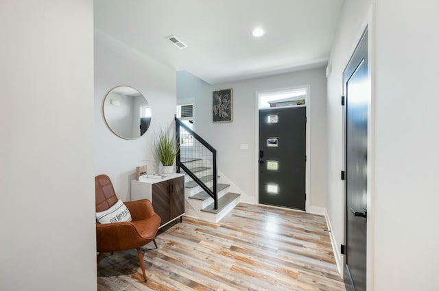 entrance foyer featuring light wood finished floors, baseboards, visible vents, recessed lighting, and stairway