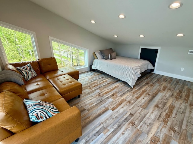 bedroom featuring baseboards, wood finished floors, visible vents, and recessed lighting