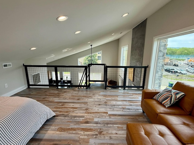bedroom with lofted ceiling, wood finished floors, visible vents, and recessed lighting