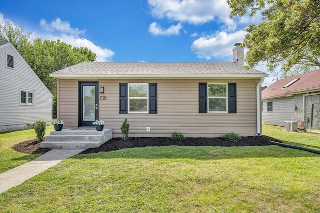 view of front of property featuring a chimney, a front lawn, central AC unit, and roof with shingles