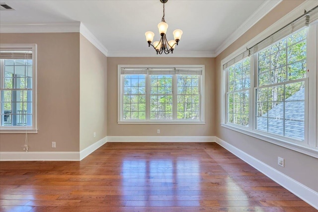 unfurnished dining area with baseboards, visible vents, hardwood / wood-style flooring, and a notable chandelier